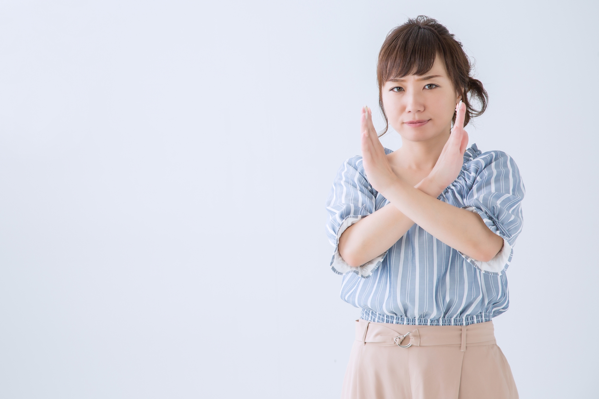 女性が×印をやっている