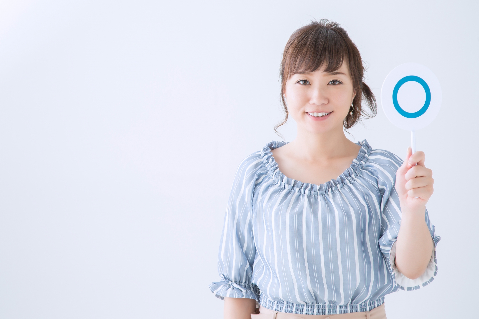 〇の札をあげている女性