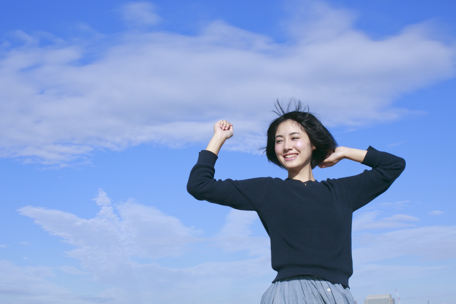 青空でにこやかにする女性