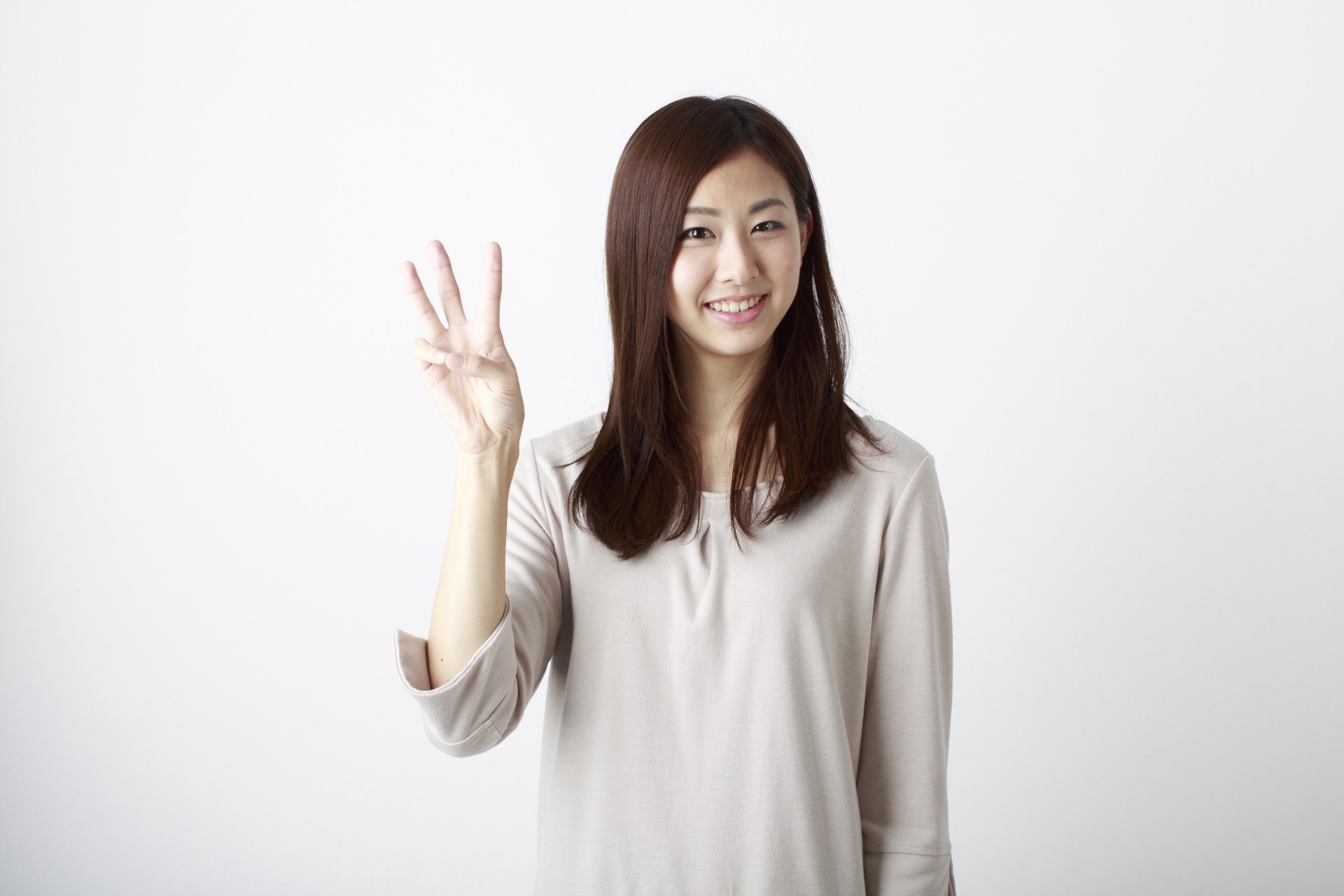 女性が3という数字を指で表現している