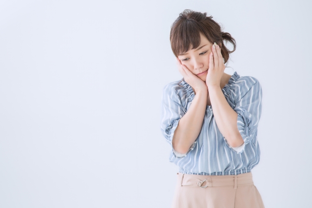 頭をかかえて悩む女性
