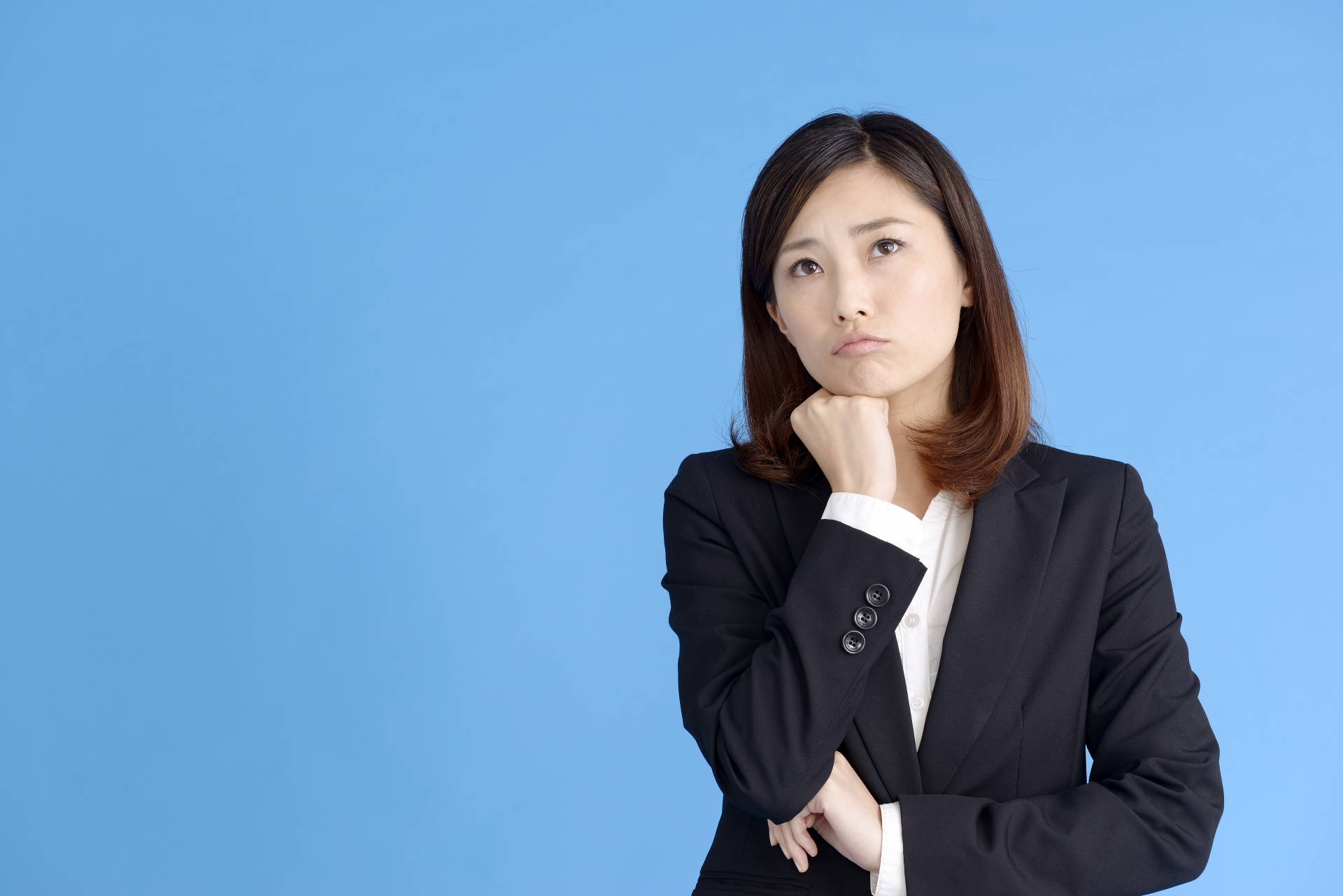 スーツを着て悩んでいる女性